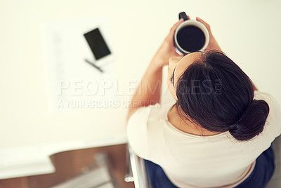 Buy stock photo High angle shot of a young businesswoman drinking coffee in her home office