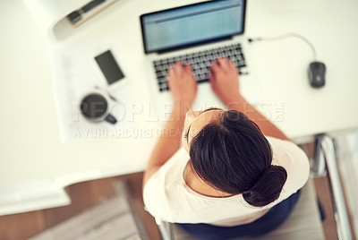 Buy stock photo High angle shot of a young businesswoman working on her laptop at home