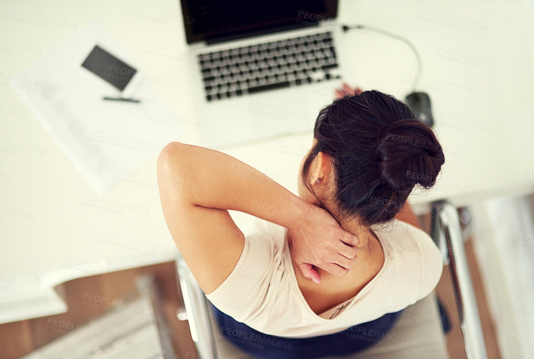 Buy stock photo High angle shot of a young businesswoman holding her neck in discomfort while working at home