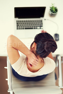 Buy stock photo High angle shot of a young businesswoman holding her neck in discomfort while working at home