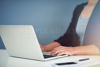Buy stock photo Cropped shot of an unrecognizable young businesswoman working on a laptop in her office