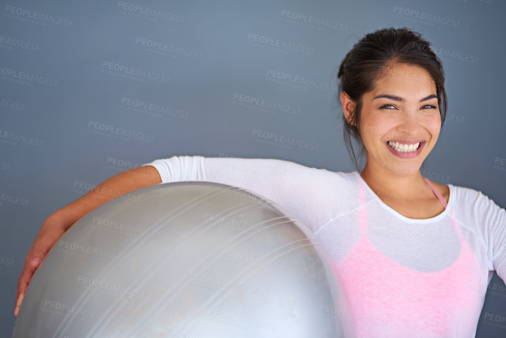 Buy stock photo Smile, happy woman and exercise ball in portrait on floor for core workout, balance and weight loss in studio. Yogi, health and training equipment for fitness, wellness and cardio on grey background
