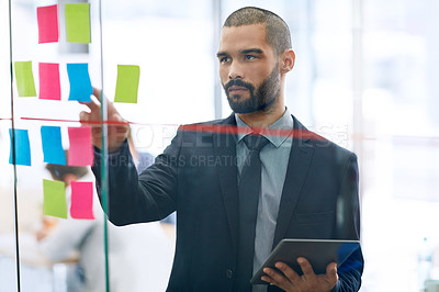 Buy stock photo Cropped shot of a young businessman working at the idea board