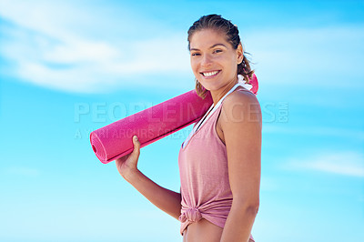 Buy stock photo Shot of a young woman holding a yoga mat while standing outside