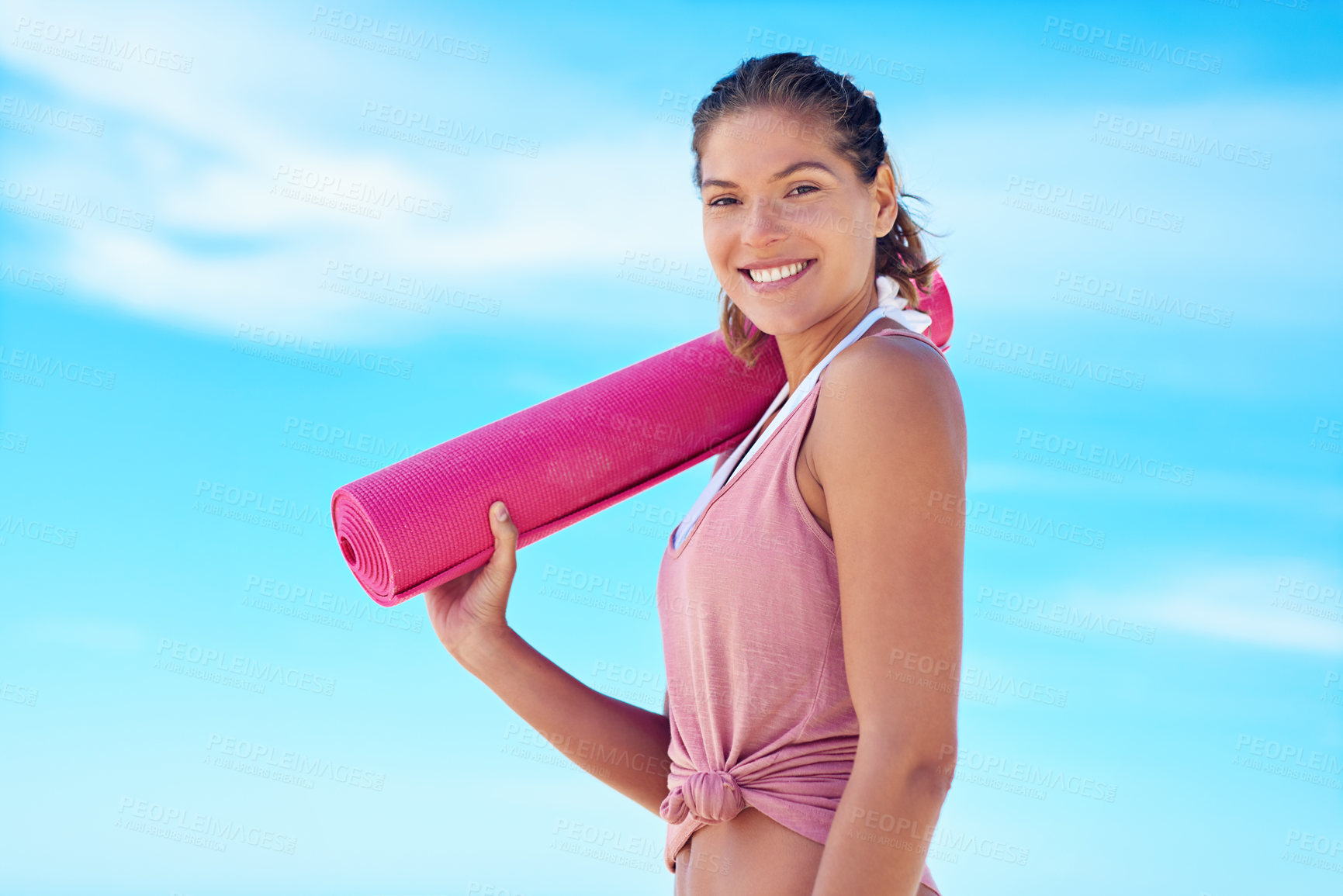 Buy stock photo Shot of a young woman holding a yoga mat while standing outside