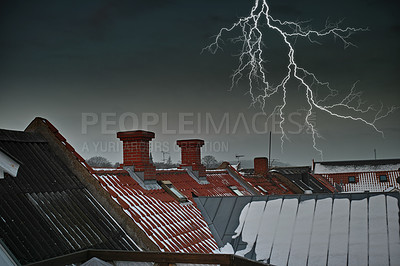 Buy stock photo Thunder striking above chimney on red tiled roof. A dramatic lighting bolt in dark grey sky over a residential town with traditional slate roofing. Thunderstorm during a gloomy scary dark winter night