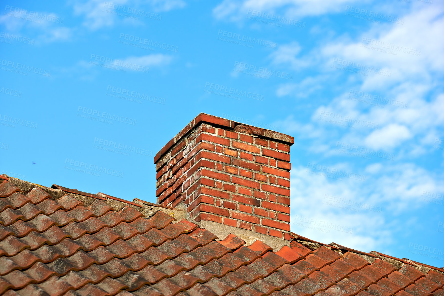 Buy stock photo Red brick chimney designed on slate roof of a house building outside with cloudy blue sky background and copyspace. Construction of exterior escape chute built on rooftop for fireplace smoke and heat