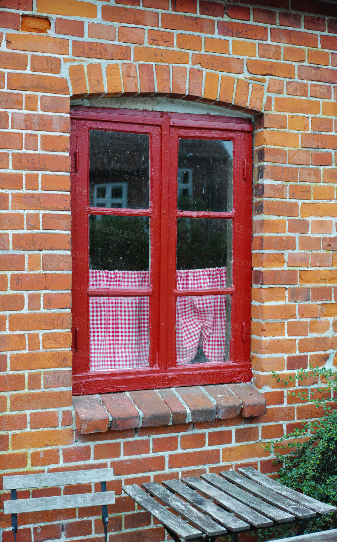 Buy stock photo Old window of a brick wall house or home. Ancient red framed casement window on a historic building with a small checkered curtain. Exterior details of a windowsill in a traditional country town