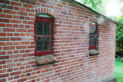 Buy stock photo Old windows on an old red brick wall of a house or home. Glass with metal red frames on historic church building and background. Architecture design on a city structure outside with copyspace