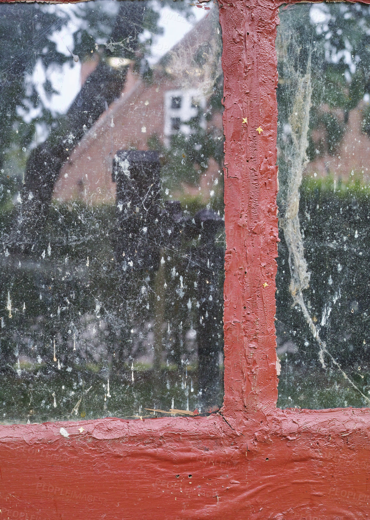 Buy stock photo Closeup of an old dirty window looking out into the neighborhood. Interior of an unclean glass window with red clumpy paint texture on the frame. Details of a windowsill in a traditional country house