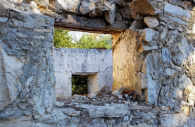 Buy stock photo Abandoned old broken house with thick crumbling stone walls. Ruins of damaged rural home with an empty window frame. Weathered antique farmhouse with traditional architecture and building design