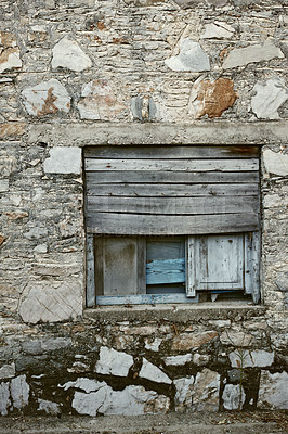 Buy stock photo Wooden window boarded on an old rough stone wall farmhouse or ancient house. Vintage, rustic, old fashioned frame and shutters on historic village building. Antique architecture structure background