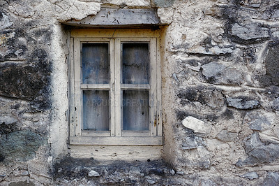 Buy stock photo Closeup of a wooden frame window on ancient house in a village. Exterior of old dirty window and wall on farmhouse. A small window and grey stone or brick wall of an old antique building or cottage