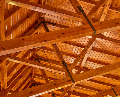 Buy stock photo Crossed wood support trestles with their angle supporters on a ceiling. Closeup of roof rafters and cross beams of a shelter. Crossed thick beige crossbeams boards for building and construction