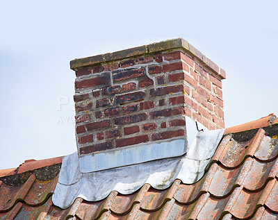 Buy stock photo Red brick chimney designed on roof of house or building outside against a sky background. Construction frame of escape chute built on rooftop for smoke and heat ventilation from a fireplace or oven