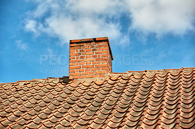 Buy stock photo Red brick chimney designed on the roof of residential house or building outside against a cloudy sky background with copyspace. Air vent construction for the release of smoke and heat from fireplace