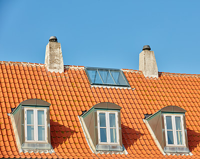 Buy stock photo Chimney chutes, windows and sunroof skylight designed on house building outside against blue sky background. Construction of exterior architecture on rooftop for fireplace escape and natural sunlight