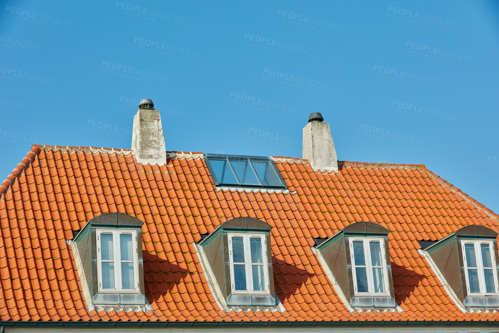 Buy stock photo Chimney chutes, windows and sunroof skylight designed on house building outside against blue sky background. Construction of exterior architecture on rooftop for fireplace escape and natural sunlight