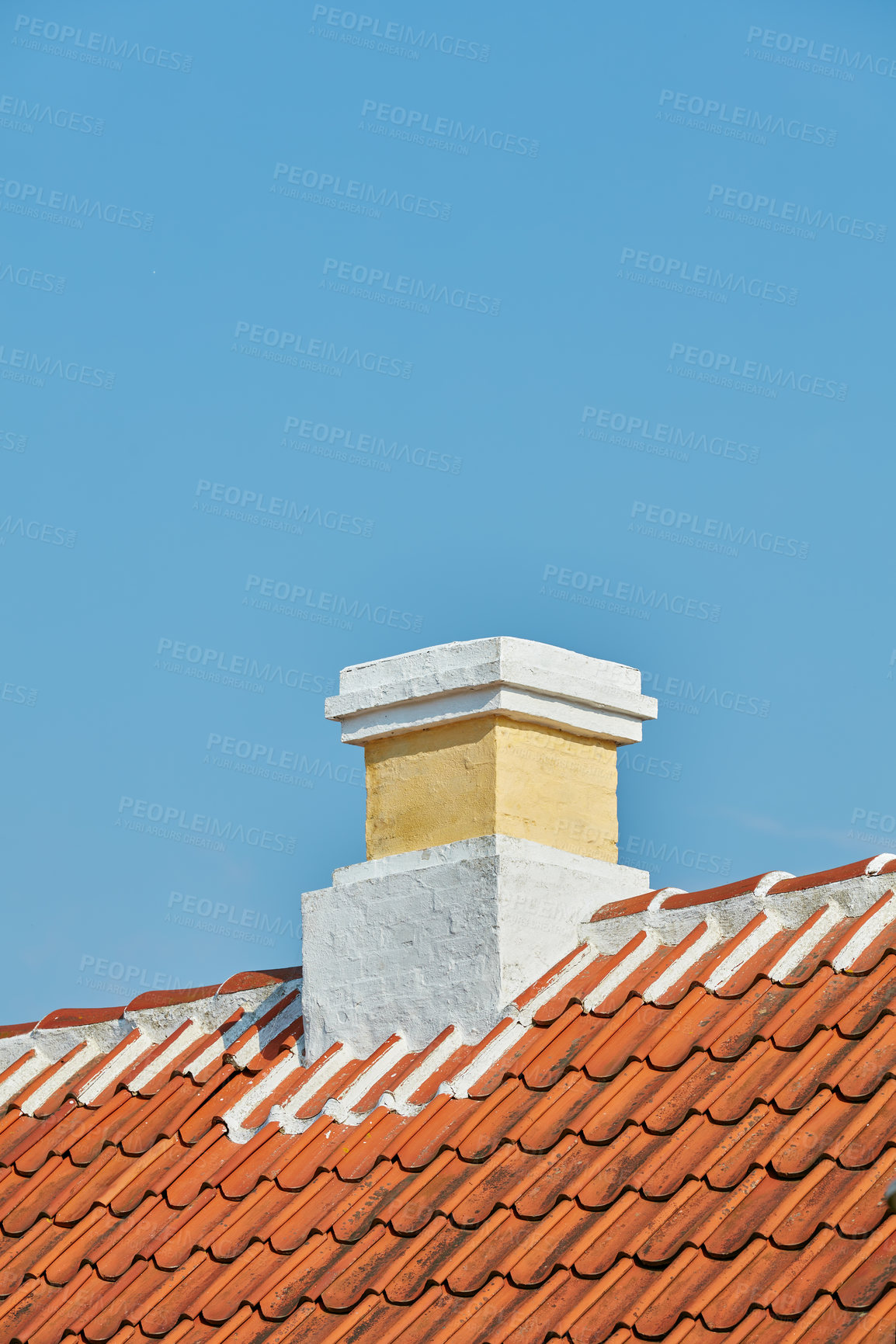 Buy stock photo Brick chimney designed on roof of house building outside against blue sky background with copyspace. Construction of exterior architecture of escape chute built on rooftop for fireplace smoke and heat