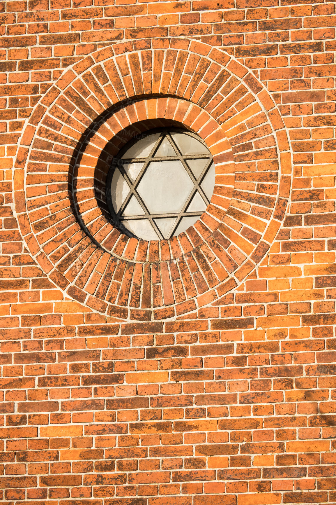 Buy stock photo A round pentagram window in a brick wall building. An old circular window in an exposed red brick exterior. Details of architecture design on church with vintage glass and metal pentagon symbol frame