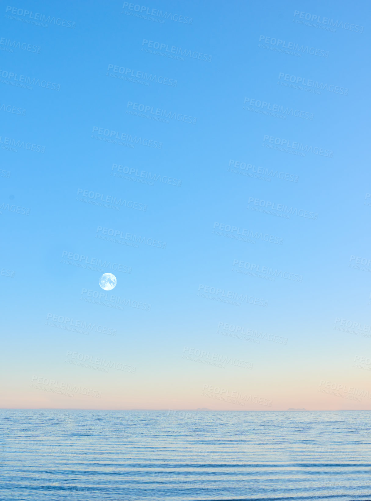 Buy stock photo Scenic view of an infinity pool with copyspace and the moon rising over a hazy horizon at sunset. Seascape of a blue sky on an empty ocean and sea at dusk. Evening over a luxury eternity swimming pool