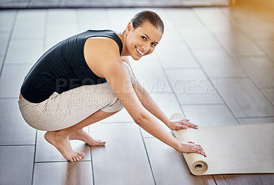 Buy stock photo Full length portrait of a of a young woman rolling out her exercise mat for yoga