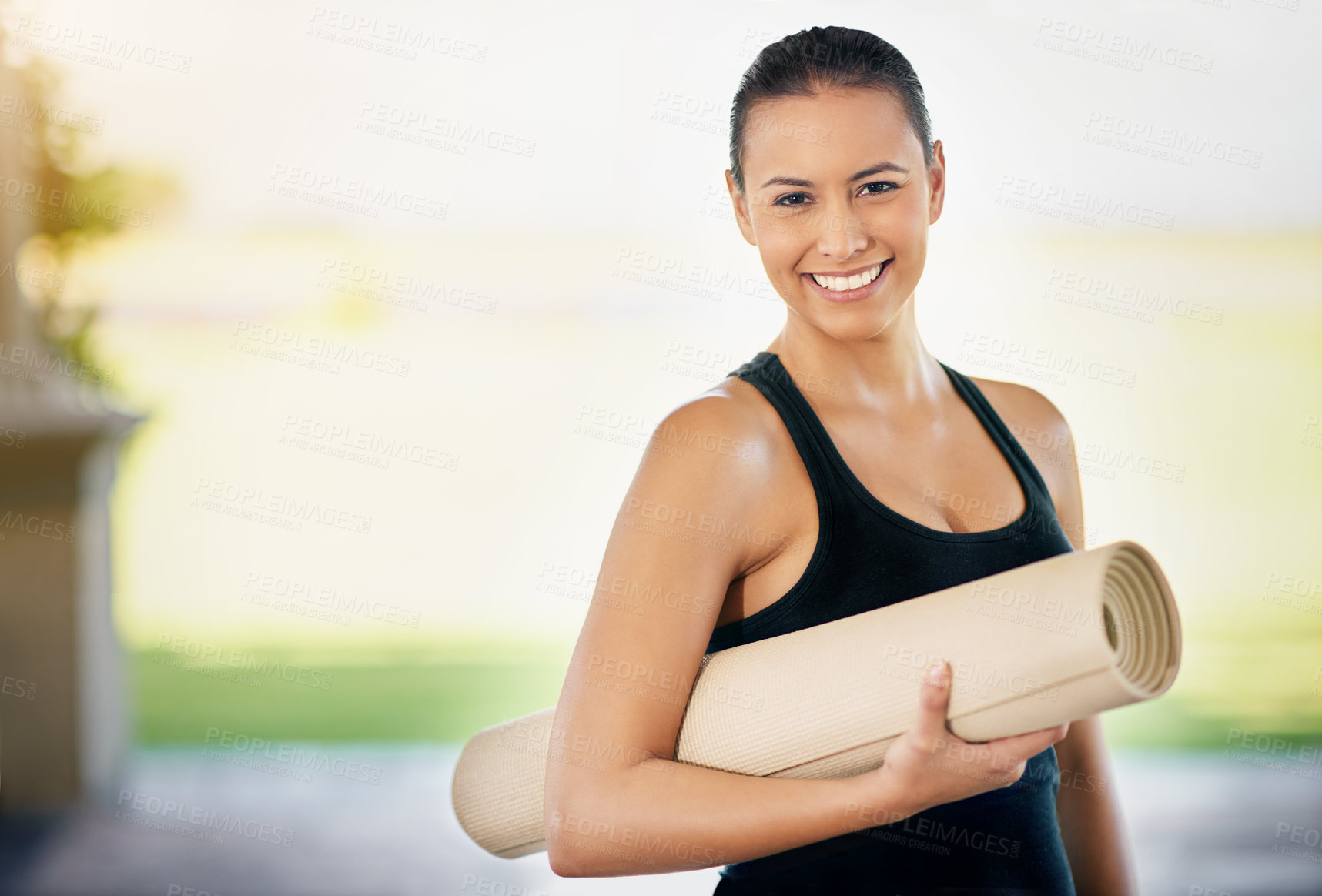 Buy stock photo Cropped portrait of a young woman carrying her exercise mat on the way to yoga