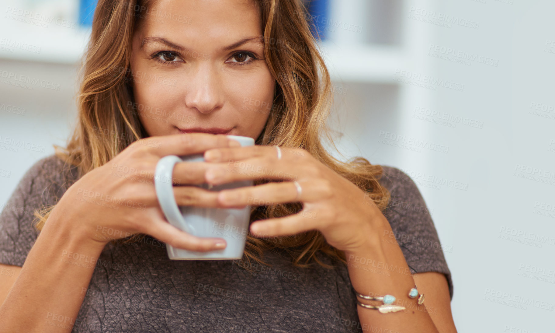 Buy stock photo Portrait of a young woman enjoying a warm beverage at home