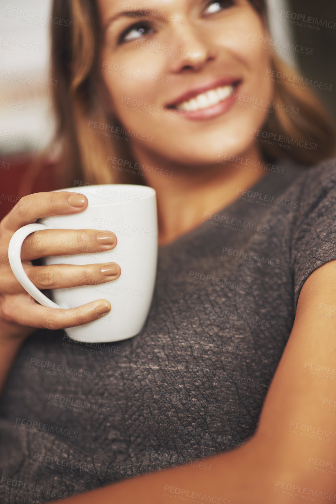 Buy stock photo Shot of a young woman enjoying a warm beverage at home