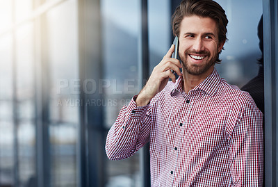 Buy stock photo Shot of a young businessman talking on a phone outside of an office building
