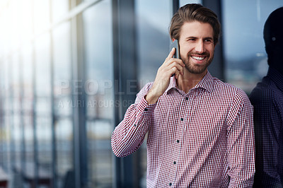 Buy stock photo Shot of a young businessman talking on a phone outside of an office building