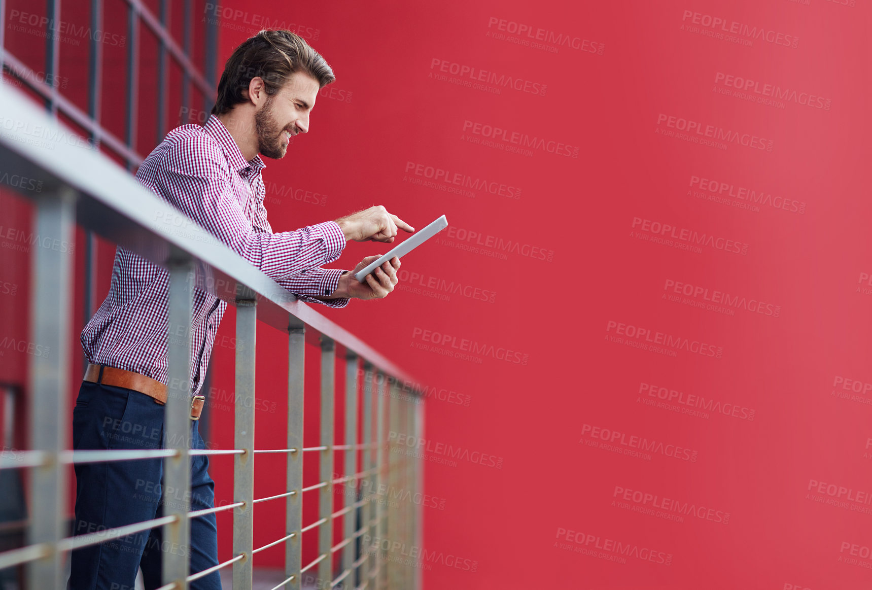 Buy stock photo Shot of a young businessman using a digital tablet on the balcony of an office building