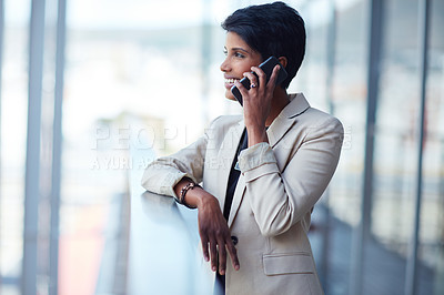 Buy stock photo Shot of a young businesswoman talking on a phone outside of an office building