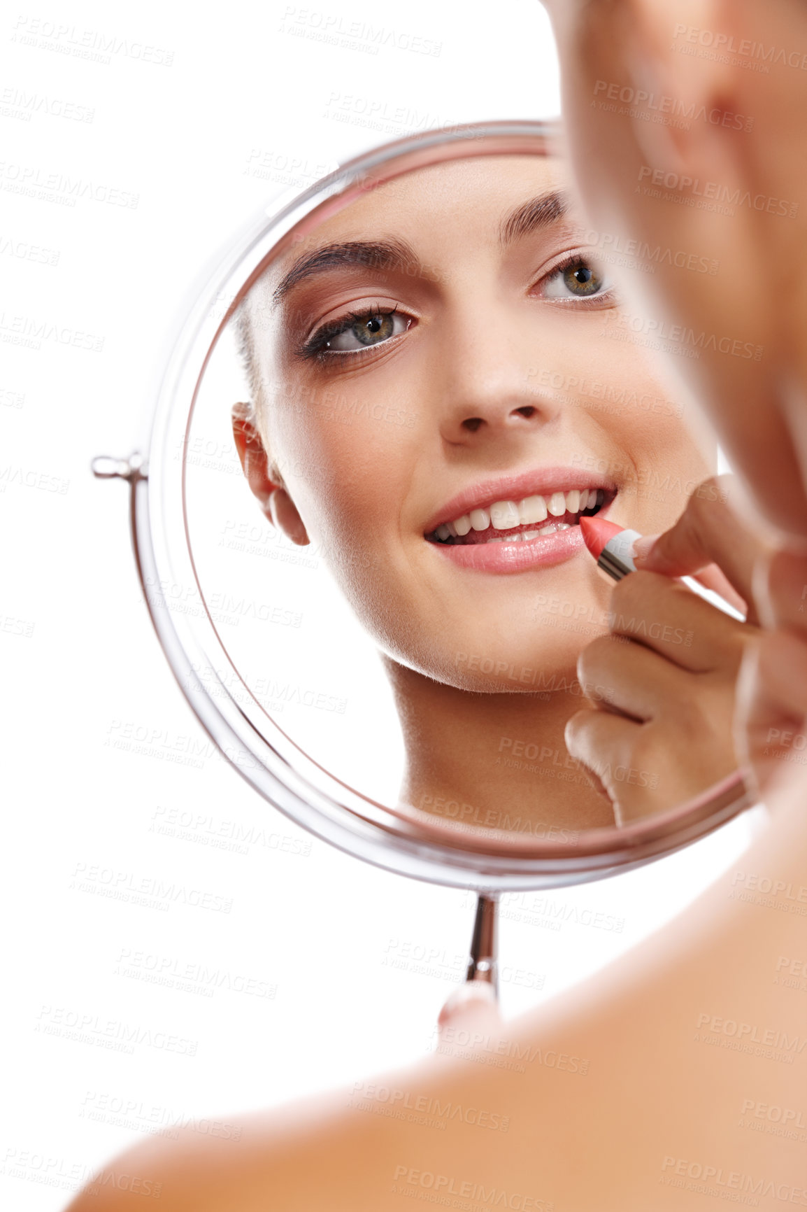 Buy stock photo Over the shoulder studio shot of a beautiful woman applying lipstick reflected in a mirror