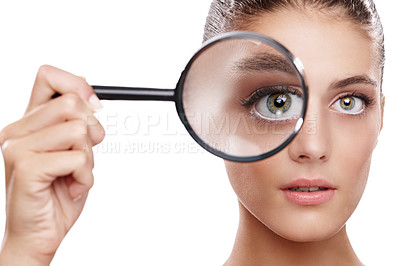 Buy stock photo Studio shot of a beautiful woman with a magnifying glass in front of her eye
