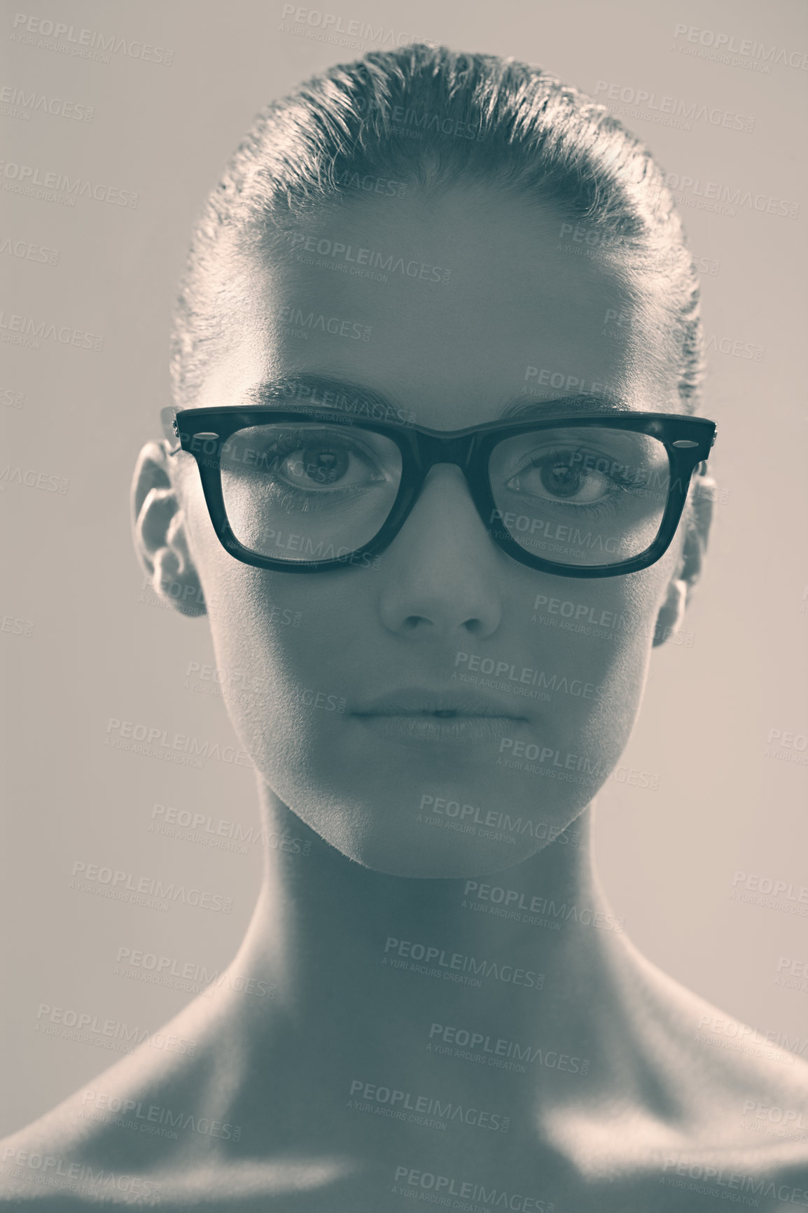Buy stock photo Monochrome studio portrait of a beautiful woman wearing glasses in grey tones