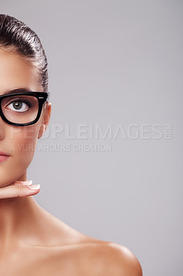 Buy stock photo Cropped studio portrait of a beautiful young woman wearing glasses against a gray background