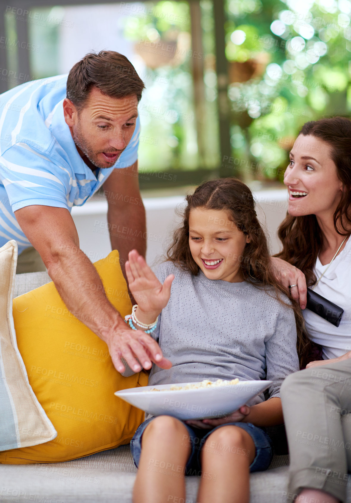 Buy stock photo Cropped shot of a father teasing his daughter while watching a movie