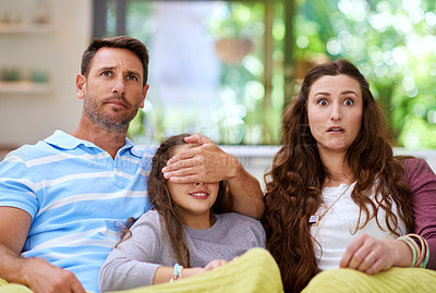 Buy stock photo Cropped shot of a father covering his daughter's eyes while watching a movie