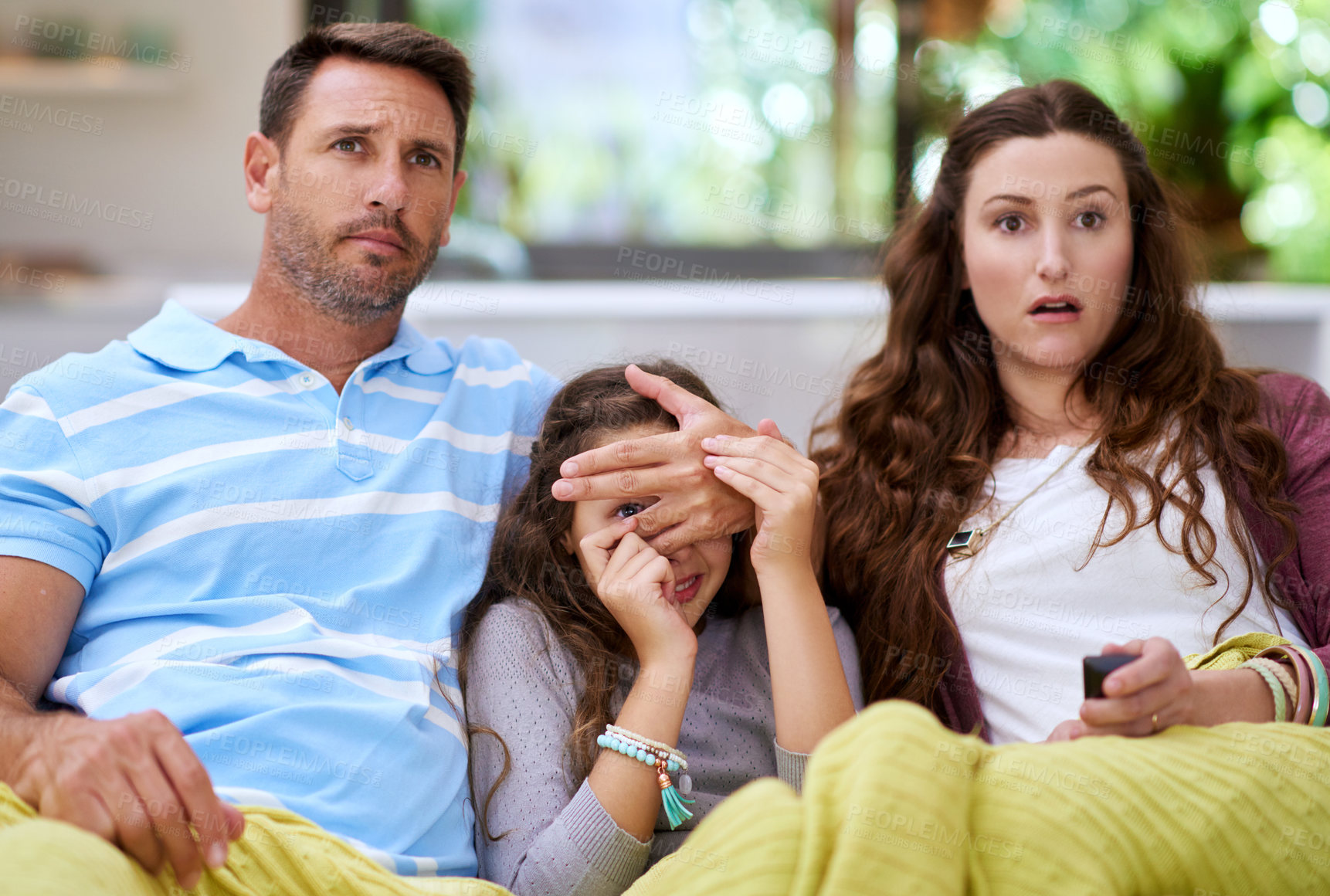 Buy stock photo Cropped shot of a father covering his daughter's eyes while watching a movie