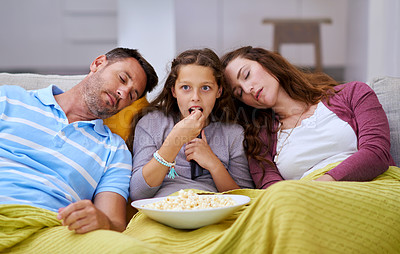 Buy stock photo Cropped shot of a young girl watching a movie while both her parents sleep on either side of her