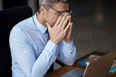 Buy stock photo Cropped shot of a mature businessman looking anxious while working in his office