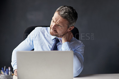 Buy stock photo Cropped shot of a mature businessman running his neck anxiously while working in his office
