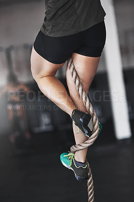 Buy stock photo Cropped shot of a young woman climbing a rope at the gym