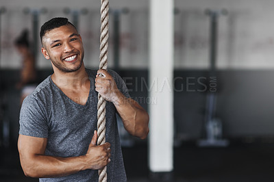 Buy stock photo Cropped portrait of a young man climbing a rope at the gym