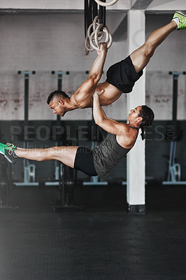 Buy stock photo Full length shot of two young athletes working out on the gymnastics rings