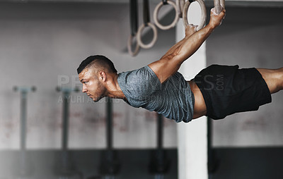 Buy stock photo Cropped shot of a young man working out on the gymnastics rings