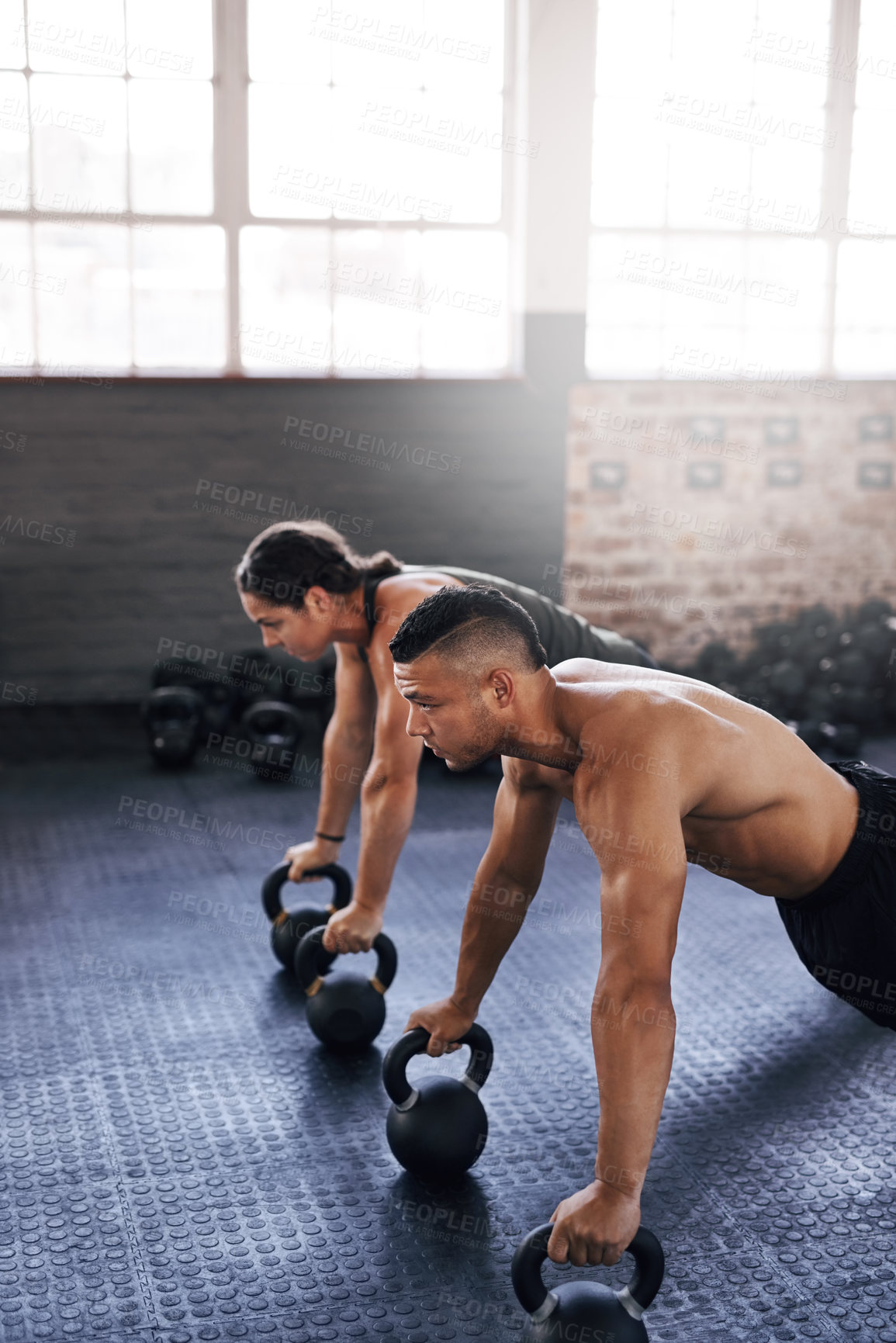 Buy stock photo Cropped shot of two young athletes working out in the gym