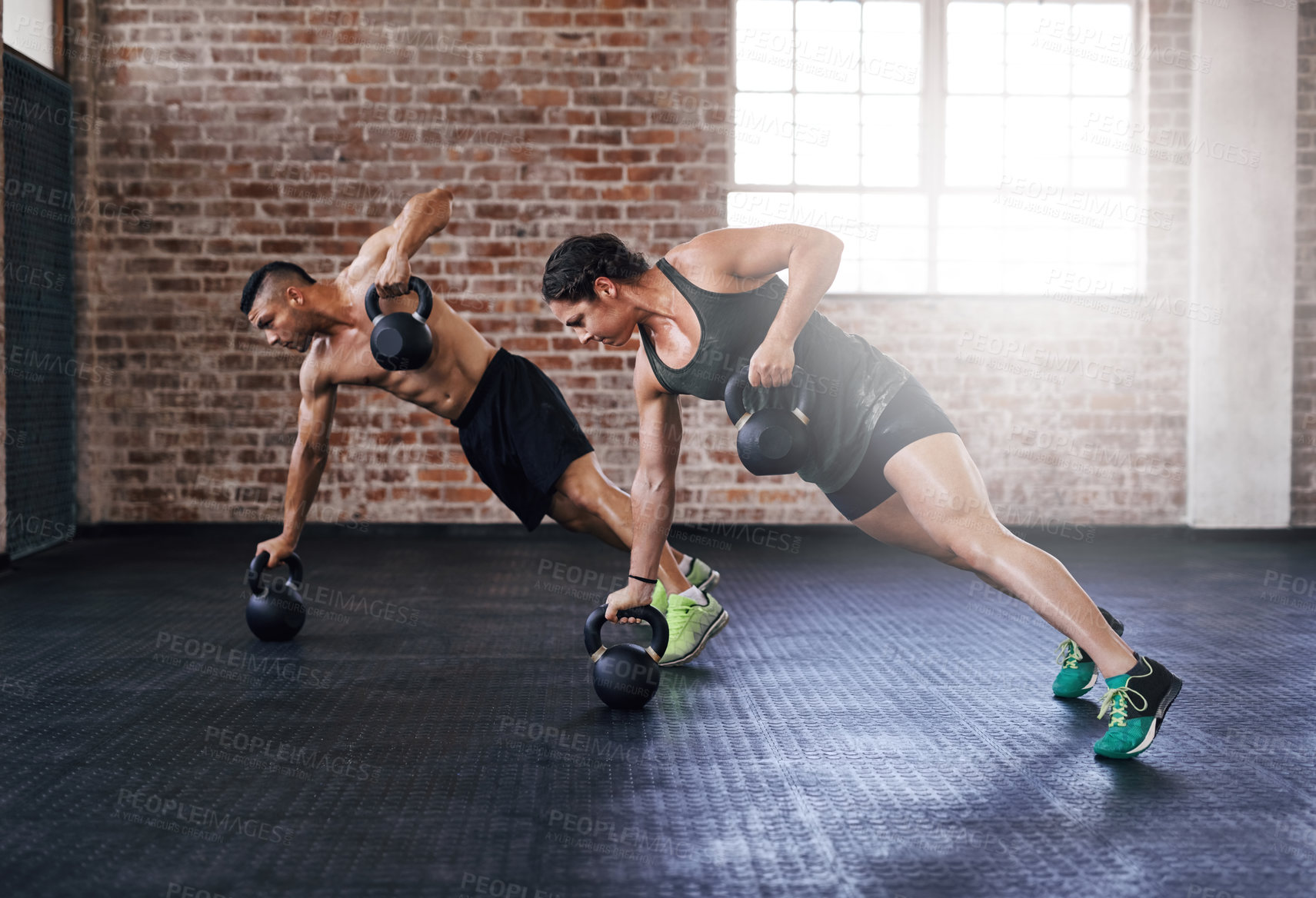Buy stock photo Full length shot of two young athletes working out in the gym
