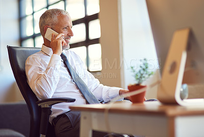 Buy stock photo Shot of a mature businessman using his phone in the office